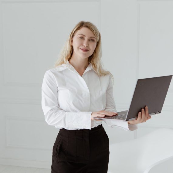 Kobieta stojąca z laptopem w ręce